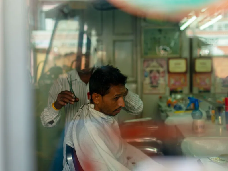 Barber shop customer getting a haircut, appointments managed with booking software