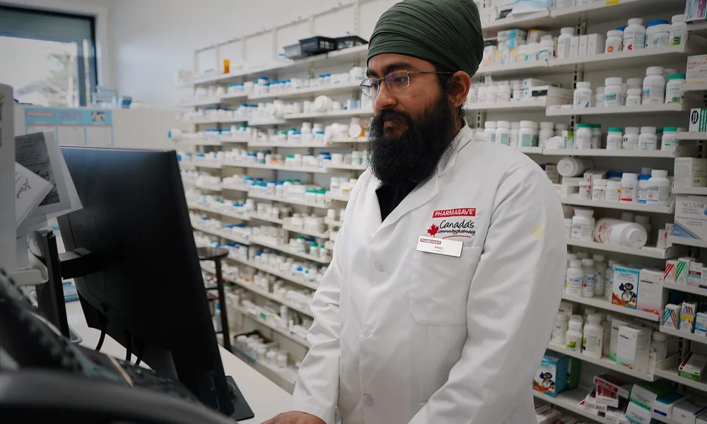 Pharmacist at a medical store computer using pharmacy software